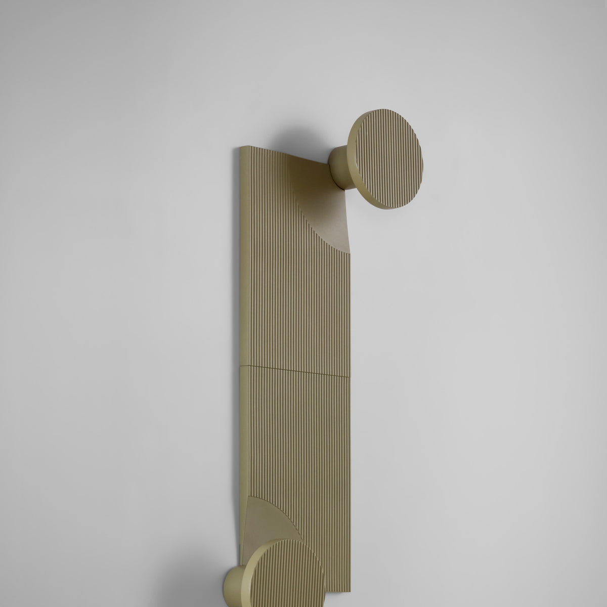 Arid Wall Light Tile in Textured Olive Grey, a fluted aluminium panel mounted beside a round wall light with ribbed shade, shown against a plain light grey background.