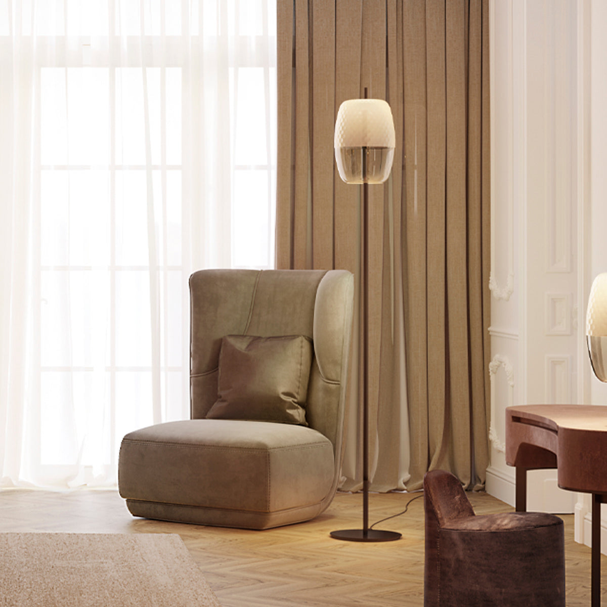 Adamas Smoke Grey Glass LED Floor Lamp with faceted honeycomb-patterned shade on a slim black stem and round base, shown beside an armchair in a living room setting.