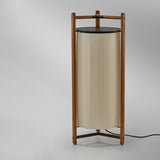 Kando P/111 Ribbon LED floor lamp with a tall pleated white cylinder shade inside a wooden three-legged frame and dark top disc, shown on a plain grey background.