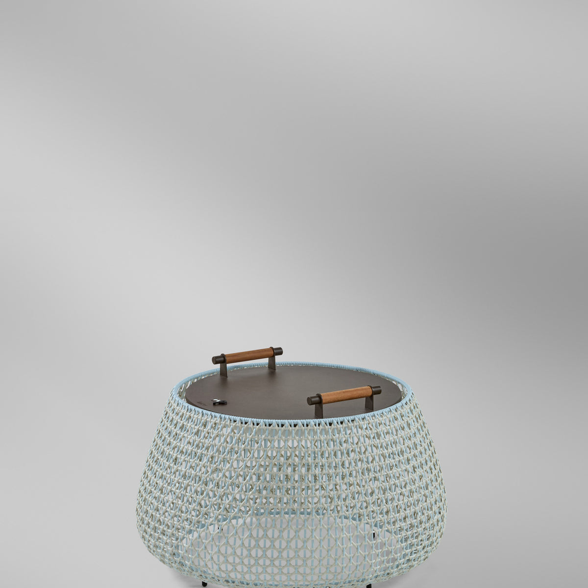 Nans Bag/38/R rechargeable outdoor floor lamp with round open-weave basket body in beige and light blue, dark flat top with two wood-grip handles, on a plain light grey background.