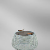 Nans Bag/38/R rechargeable outdoor floor lamp with round open-weave basket body in beige and light blue, dark flat top with two wood-grip handles, on a plain light grey background.