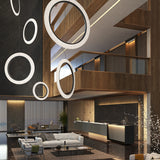 Roda S/120/V Ribbon Ring LED Pendant Light in white, shown as a large circular ring with pleated translucent fabric, hung in multiple sizes above a modern hotel lobby lounge.