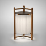 Kando P/76/R rechargeable LED floor lamp with pleated white ribbon shade, teak wood frame, and flat round aluminium top disc, on a plain light background.