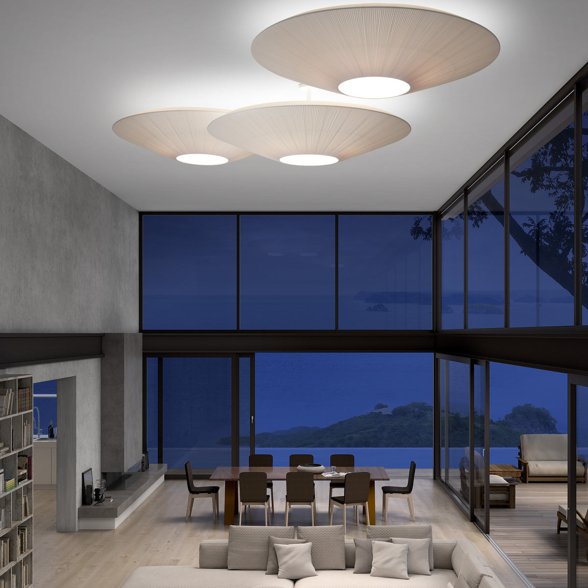 Siam 150 Ribbon ceiling lights in cream pleated fabric with round white diffusers, shown in groups of three above a living and dining area at night.