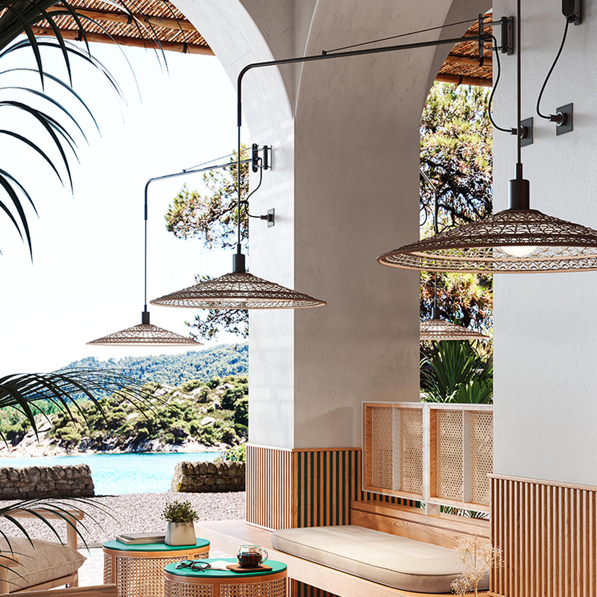 Nans 55 A/98 wall lights with long brown arms and woven cone shades in a beige fibre finish, mounted beneath an archway in a coastal-style outdoor seating area.