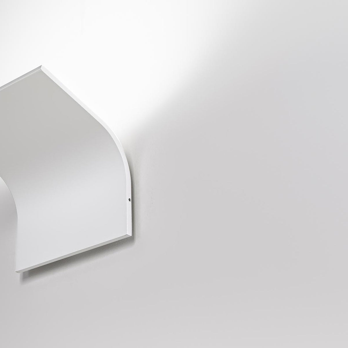 App Aluminium LED Wall Light in white, a slim curved single-plate fixture mounted flat to the wall with an integrated LED, shown in close-up against a plain light background.