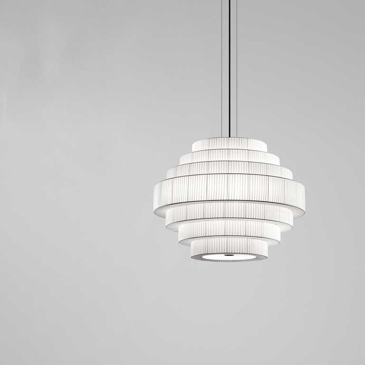 Mos 02 Ribbon Tiered Pendant Light with seven stacked pleated white translucent ribbon tiers on an iron frame, shown against a plain light grey background.