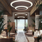 Roda S/150 Ribbon Ring LED pendant lights in white, large circular tiered fixtures suspended above a coastal-style lounge with wood beams and seating.