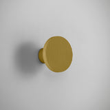 Arid A/01 round aluminium LED wall light with ribbed sand yellow disc and short projecting stem, shown against a plain light grey background.