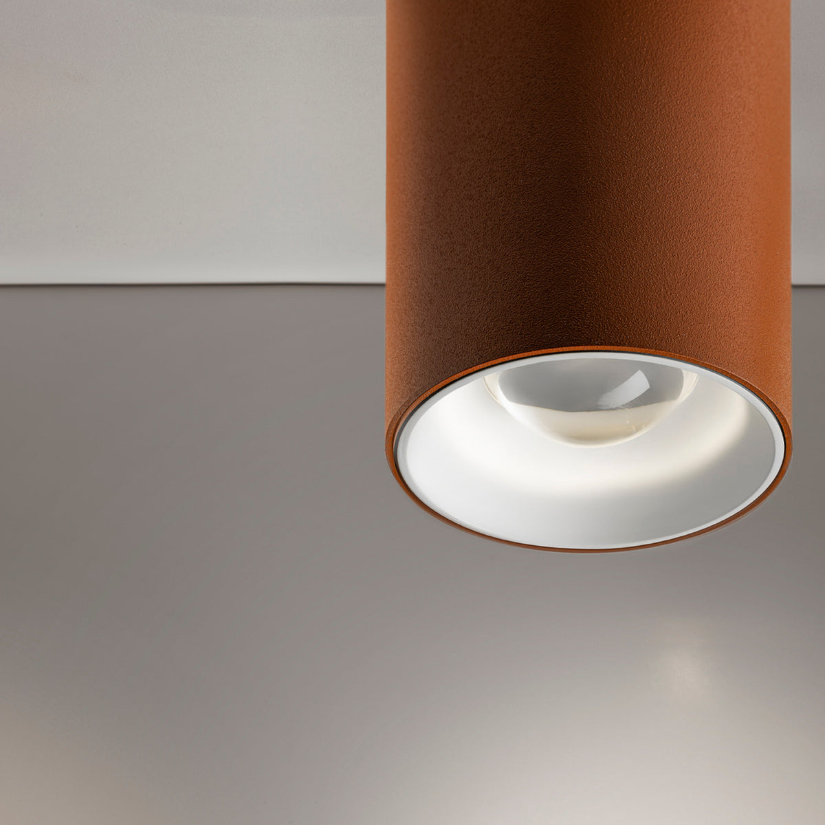 432 Ways Cylinder LED Ceiling Light in brown, close-up of the cylindrical surface-mounted fixture with recessed white trim and integrated LED, against a plain grey ceiling.