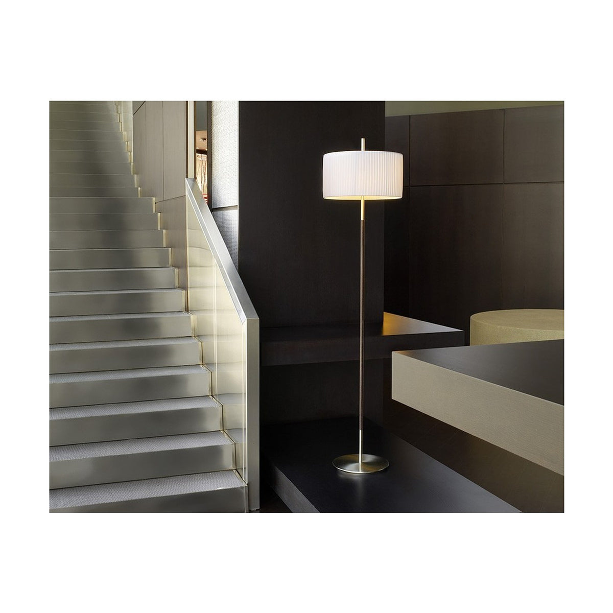Danona P Fabric Drum Floor Lamp with a white pleated shade on a slim satin nickel stem and round base, shown beside a staircase in a modern interior.
