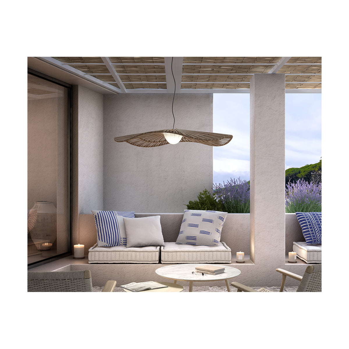 Mediterrània S/105 outdoor pendant light with wide disc-shaped brown fibre slat shade and white ribbed LED diffuser, hung above a patio seating area.
