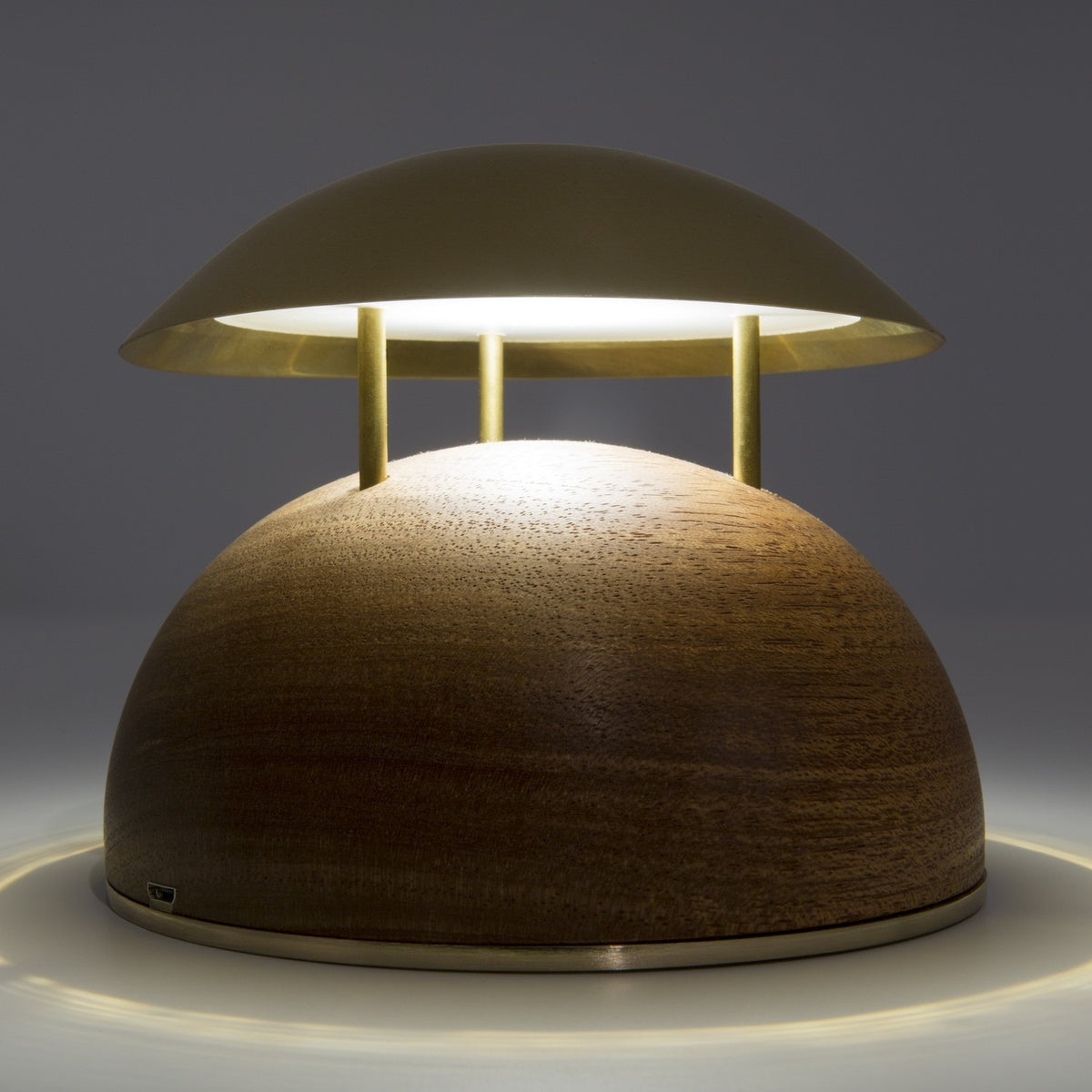 Bell LED Wooden Rechargeable Outdoor Table Lamp with domed brass-coloured metal shade on three slim rods above a wood dome base, warm white light, grey background.