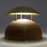 Bell LED Wooden Rechargeable Outdoor Table Lamp with domed brass-coloured metal shade on three slim rods above a wood dome base, warm white light, grey background.