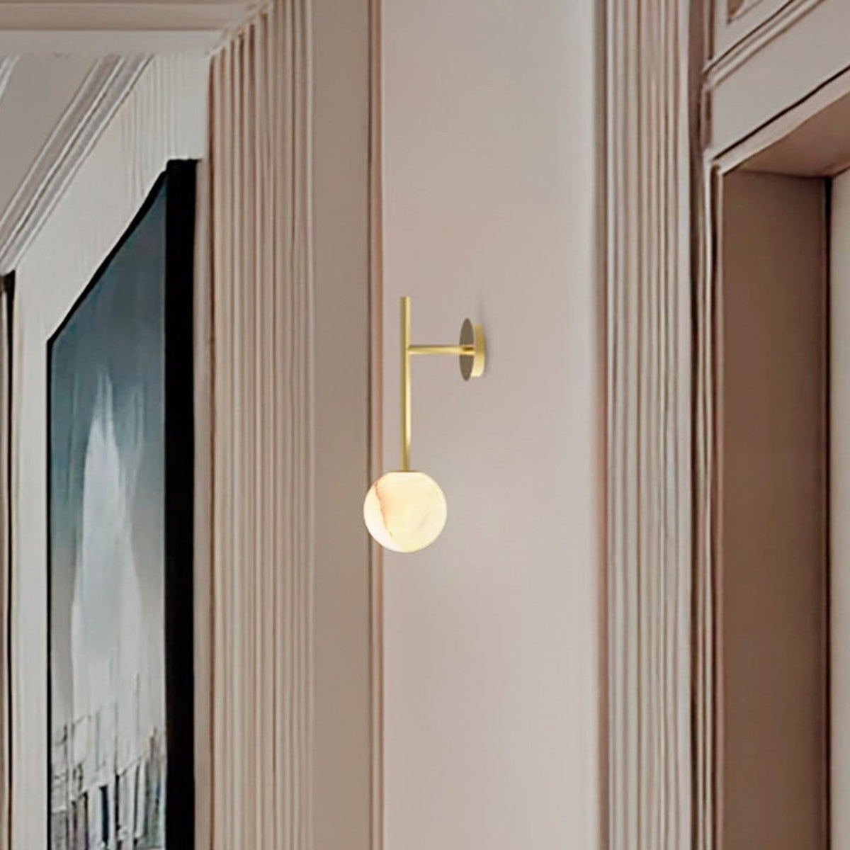 Royal Single Arm Alabaster Globe Wall Light in Gold, mounted in a hallway with a slim brass arm and round alabaster shade with soft veining.