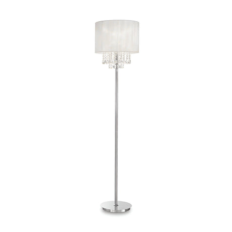 The Brillis Crystal Floor Lamp - Chrome is a luxurious lighting piece, showcasing a sleek chrome finish with a slim silver stand and a round white lampshade. Elegantly hanging crystal-like beads adorn the area beneath the shade, while the lamp stands gracefully on a flat circular base.