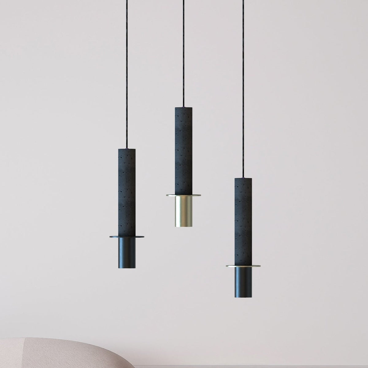 Rita Concrete Pendant lights in matt black with a disc detail and brass and black iron heads, shown in three lengths against a plain light background.