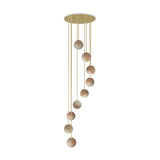 Royal Spiral chandelier with nine alabaster globes on gold cables, cascading from a round brass ceiling disc against a plain white background.