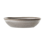 Sandrine stoneware deep plate in light grey, oval organic shape with speckled reactive glaze and darker rimline, shown on a plain white background.