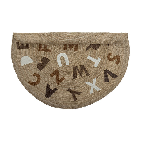 Dinne Round Jute Rug 130cm in beige, folded in half, showing scattered capital letters in brown, white and tan tones on a plain white background.