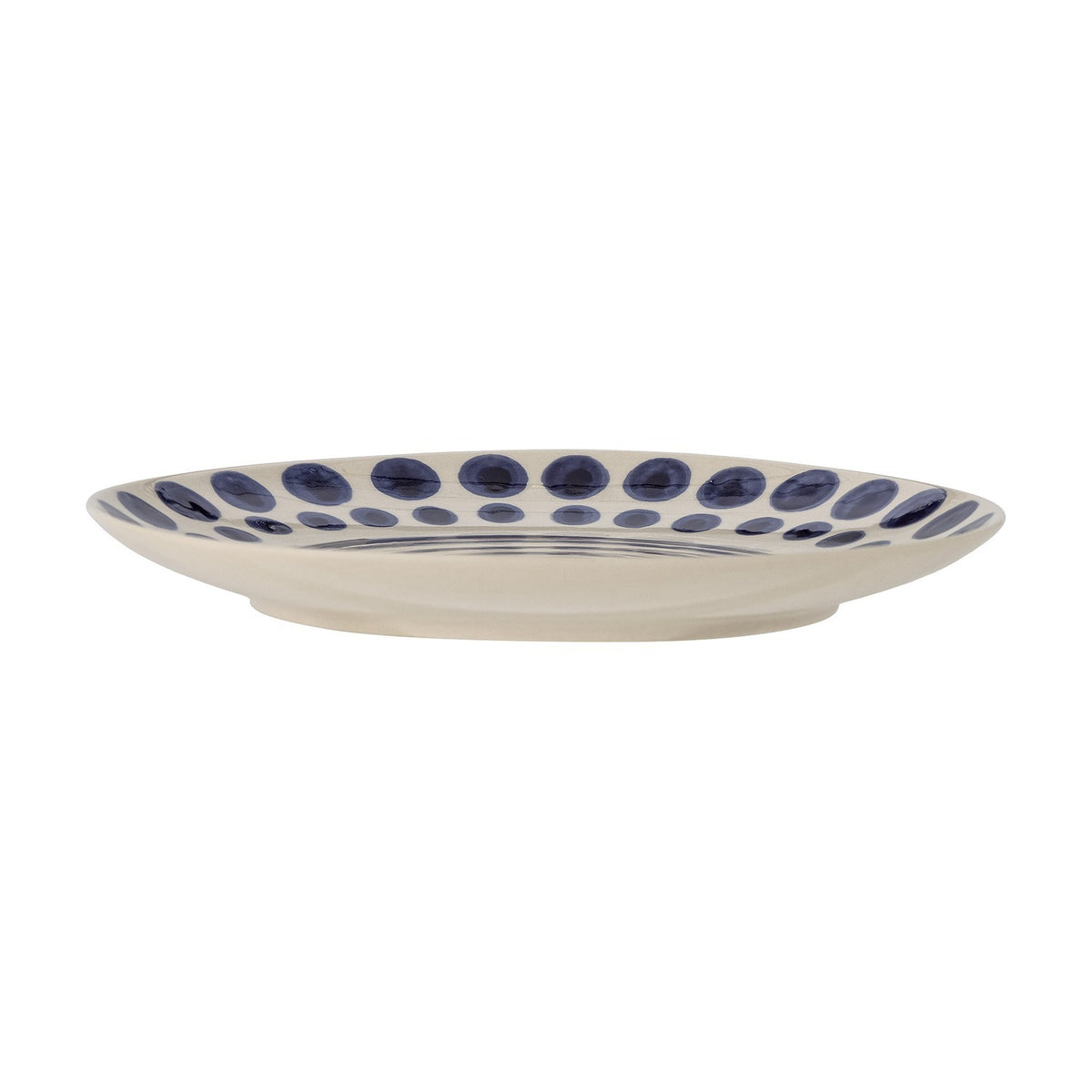 Shama Dotted Stoneware Side Plate in cream with hand-painted navy dots around the rim and a subtle spiral centre, shown side-on against a white background.