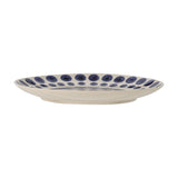 Shama Dotted Stoneware Side Plate in cream with hand-painted navy dots around the rim and a subtle spiral centre, shown side-on against a white background.