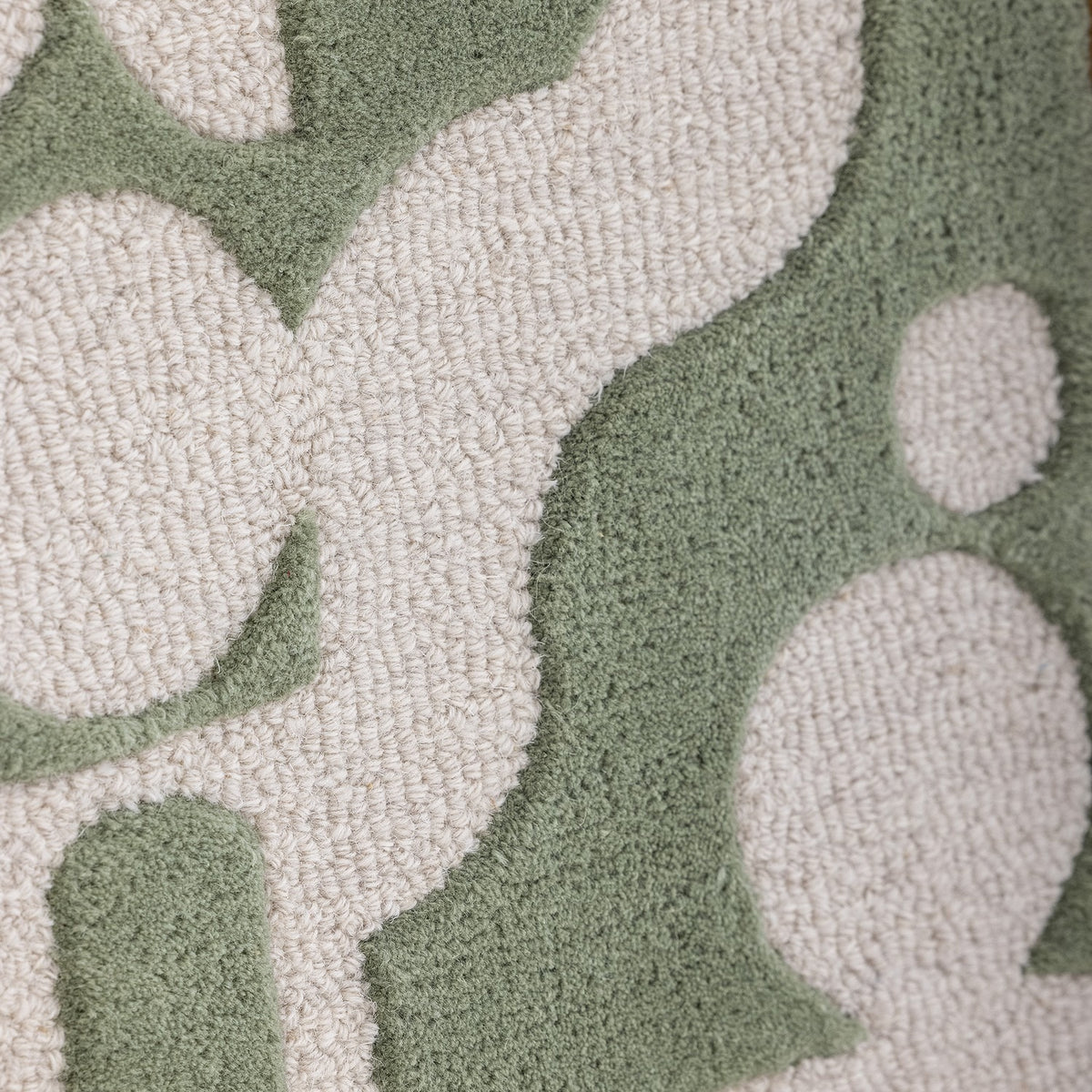 Close-up of the Longton Wool Wall Decor in green, showing tufted abstract shapes in cream against a denser green ground with a looped textile texture.