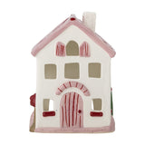 Shirly House stoneware Christmas tealight holder in white, with a pink pitched roof, chimney, cut-out windows and a hand-painted arched door, shown on a plain background.