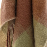 Close-up of the Hamisha Throw in Multi, a woven polyester check throw in rust, sage and tan tones, showing the soft fabric texture and twisted fringe edge.