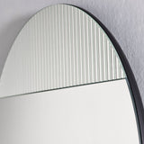Close-up of the upper arc, the ribbed panel and the plain mirror meeting on the same frameless sheet of glass.