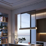 Aluet S/100 LED pendant light with a half-round ash wood shade in beige, hung on cotton straps above a kitchen counter with a sea view through the window.