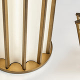 Close-up of the Roma LED table lamp's round scalloped base in Brushed Bronze, showing slim vertical bars framing a white glass panel shade, against a plain light background.