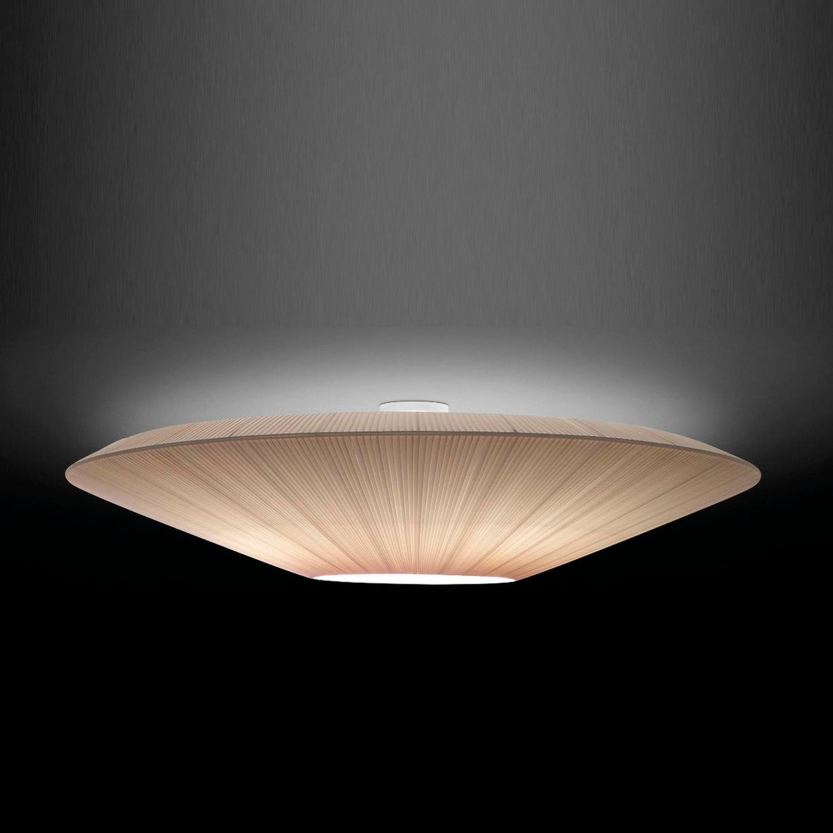 Siam 150 Ribbon ceiling light with a wide, shallow cream translucent pleated shade and round white diffuser, glowing against a dark background.