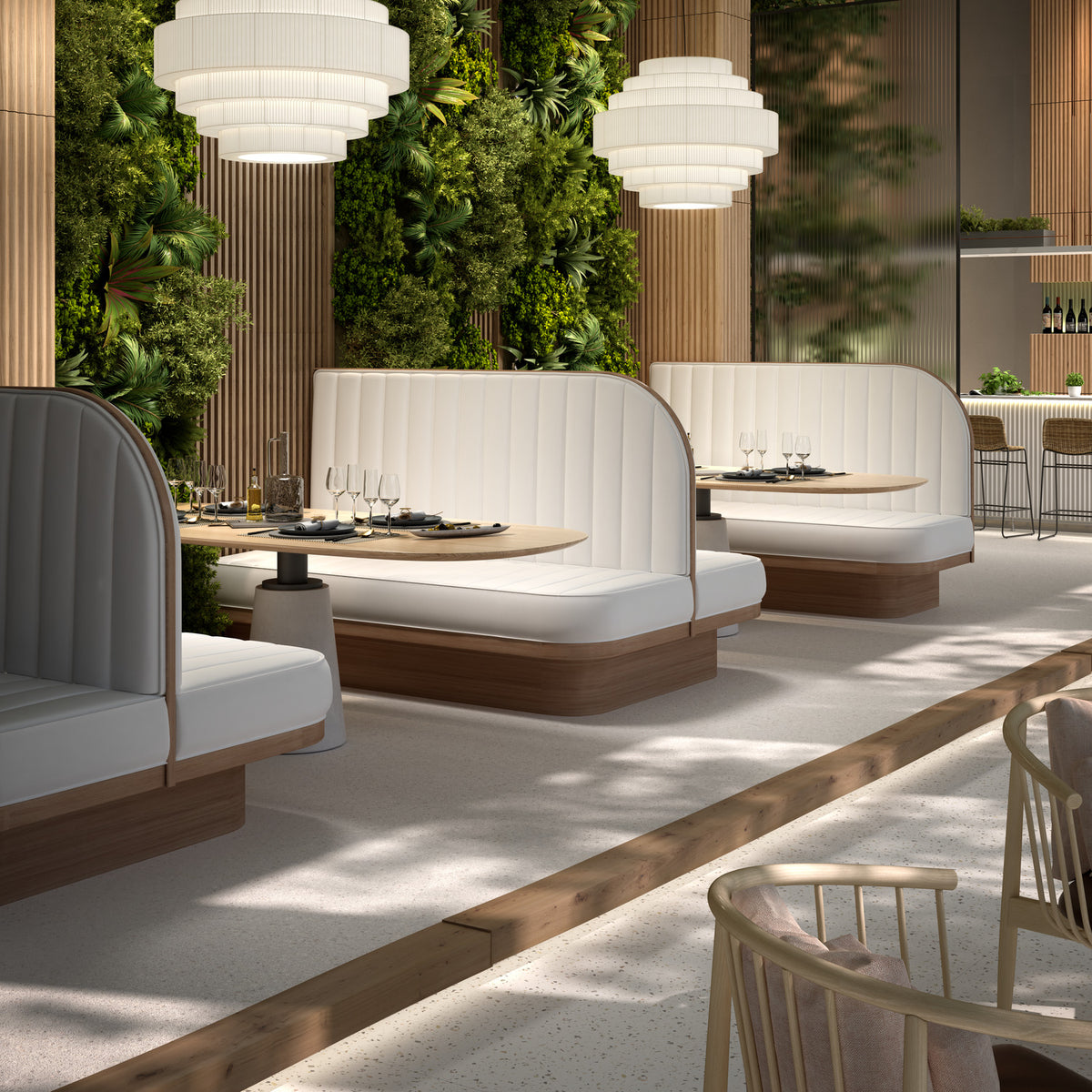 Mos 02 Ribbon Tiered Pendant Lights with white translucent pleated shades hanging over booth seating in a restaurant dining area with greenery backdrop.