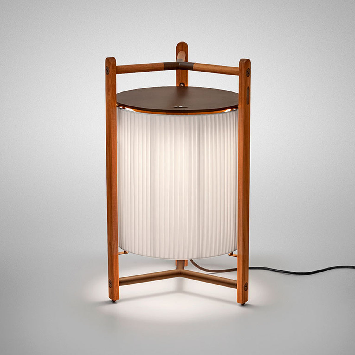 Kando P/76 Ribbon LED floor lamp with cream pleated cylinder shade, teak wood tripod frame, and round brown top, lit against a plain white background.