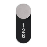 Rock Signage Tag for wall light in matt black iron, a rounded vertical plate with cut-out "126" numbering, shown behind a round light head on a white background.