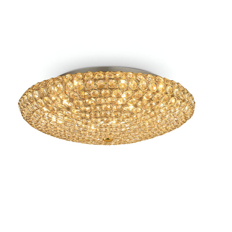 The Queen 9 Light Crystal Ceiling & Wall Light in Gold features a circular design with a textured surface made up of numerous small, round elements. This luxurious lighting fixture radiates opulence and adds an elegant touch to any space.