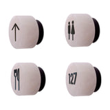 Rock wall lights with matt black iron signage symbols, shown as arrow, male/female, cutlery and room number 127 icons, on a plain white background.
