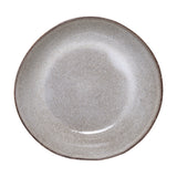 Sandrine stoneware deep plate in light grey, speckled reactive glaze with a darker rim and gently uneven edge, shown on a plain white background.