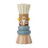 Minio Ceramic Vase 17cm, a small hand-painted bud vase with a face design in cream, tan, blue and pink tones, fluted rim and base, shown on a plain white background.
