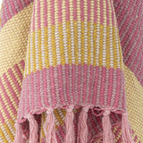 Close-up of the Isnel Striped Throw in pink, showing a raised textured weave in pink, yellow and cream stripes with knotted tassel fringe.