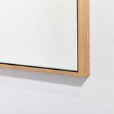 Close-up of the oak frame corner seen at an angle, showing the square section of the timber and the mitred joint.