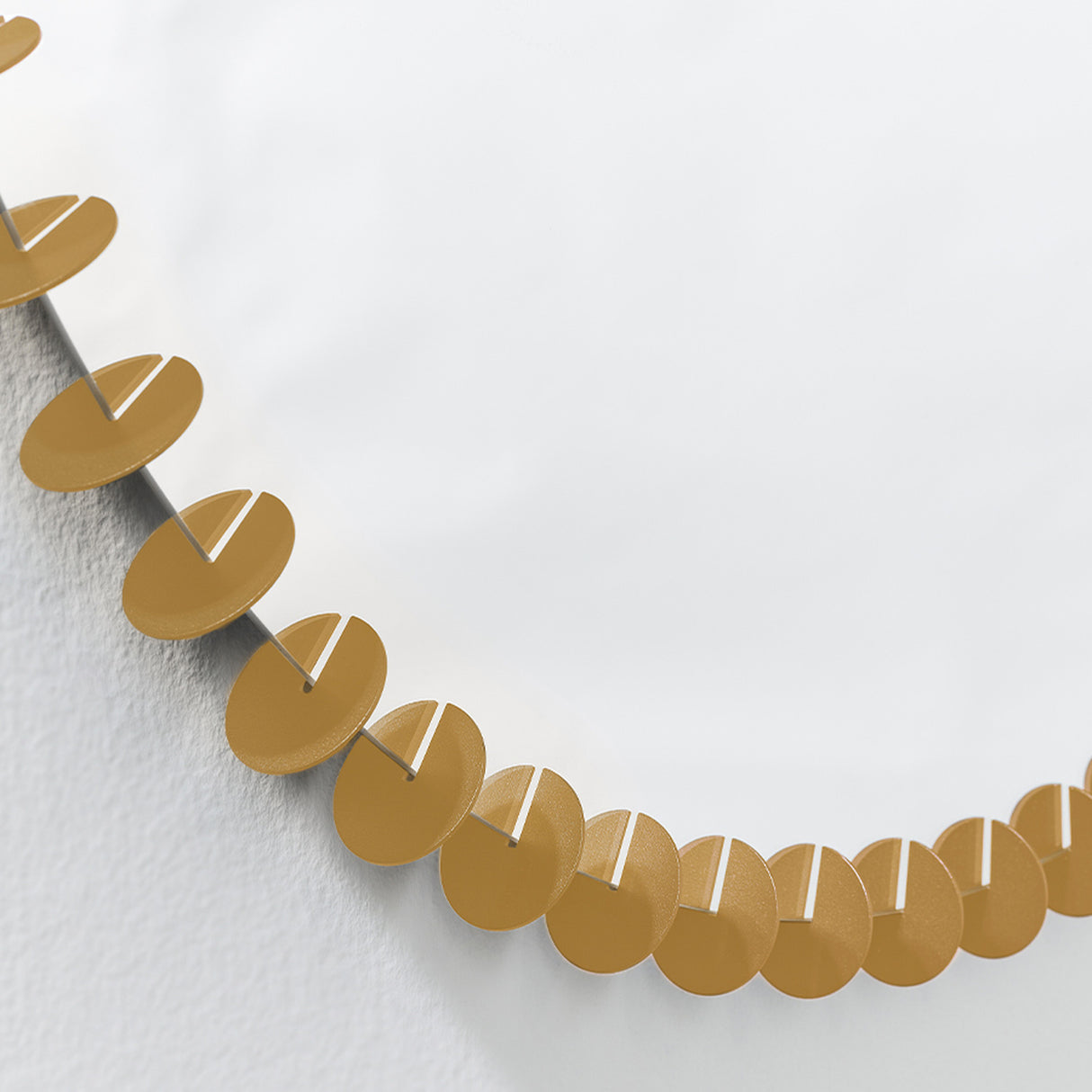 Close-up of the gold discs running around the rim, each disc slotted onto the edge and set at a slight angle.