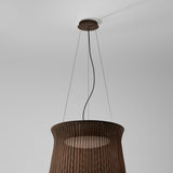 Syra 45 LED pendant light with a woven brown aluminium drum shade that narrows at the waist, suspended by three wires from a round ceiling canopy against a plain grey background.