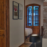 Bol M/37 Dome LED Table Lamp in matte black, with rounded dome shade on a slim stem and round base, shown on a console table in a hallway leading to a bedroom.