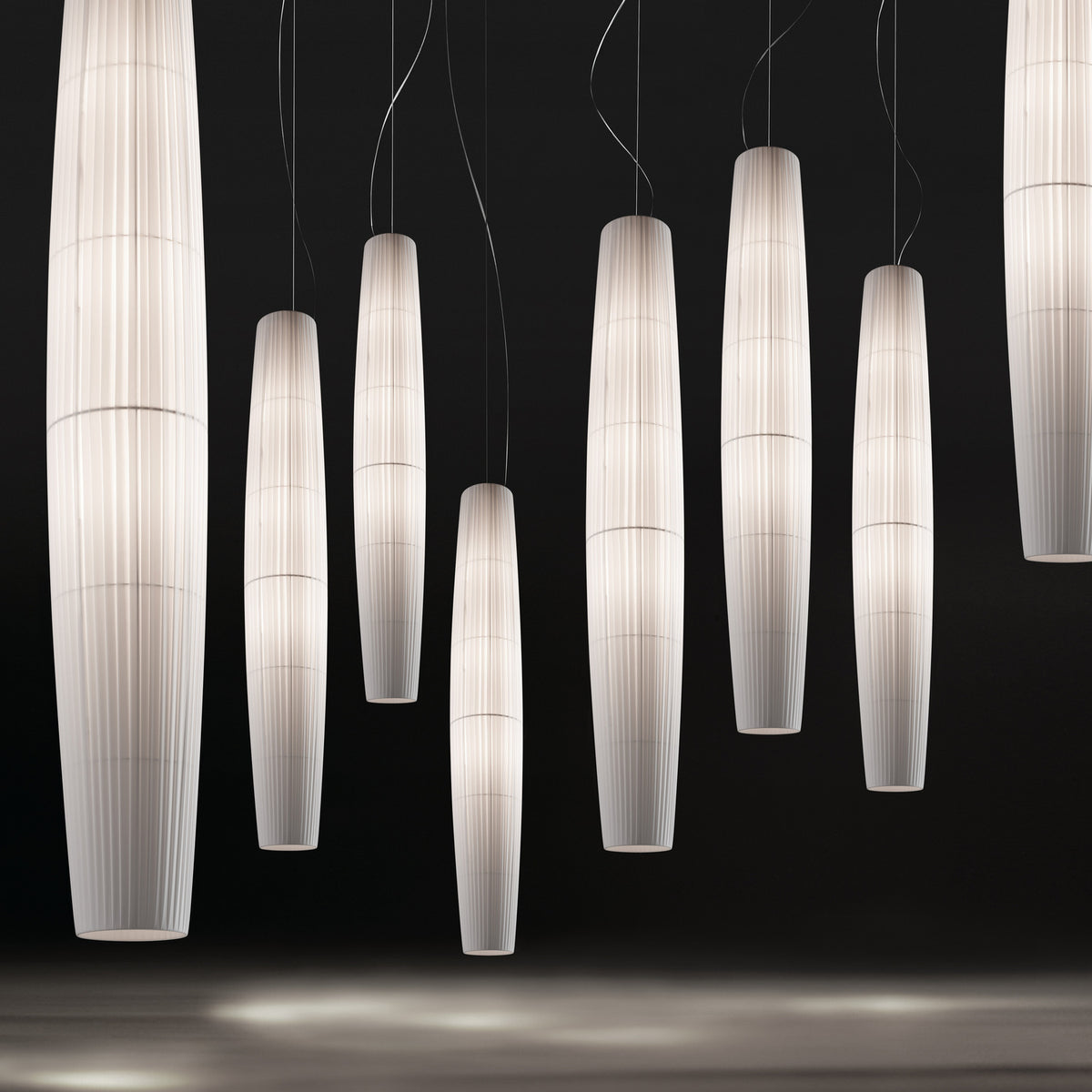 Maxi S/01 Ribbon LED pendant lights in white, tall tapered columns with fine pleated ribbon shades, shown in multiples against a dark background.