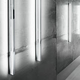 Zero Line Metal Linear LED Wall Light in chrome, slim vertical bars mounted on a textured concrete wall casting soft linear light bands.