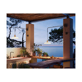 Marietta 32 A/98 outdoor wall light with white pleated cone shade on a long slim arm, mounted on pillars in an outdoor dining area overlooking the sea.