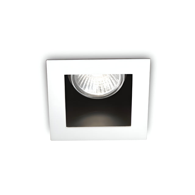 The Shimmer Recessed Downlight - White showcases a square design with a white frame and exposed bulb, providing minimalist illumination with its radiant glow. This durable lighting fixture complements the plain white backdrop, effortlessly merging aesthetic appeal with practicality.