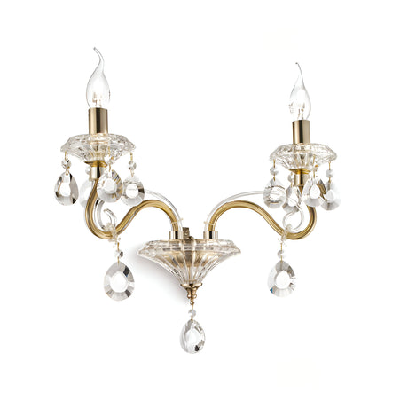 The Prismara 2 Light Glass Wall Light in a gold-tone finish features classic two-arm styling with cut crystal accents. Each glass arm supports a candle-shaped bulb, adorned with decorative teardrop crystals that hang below to reflect light and create a sparkling effect.